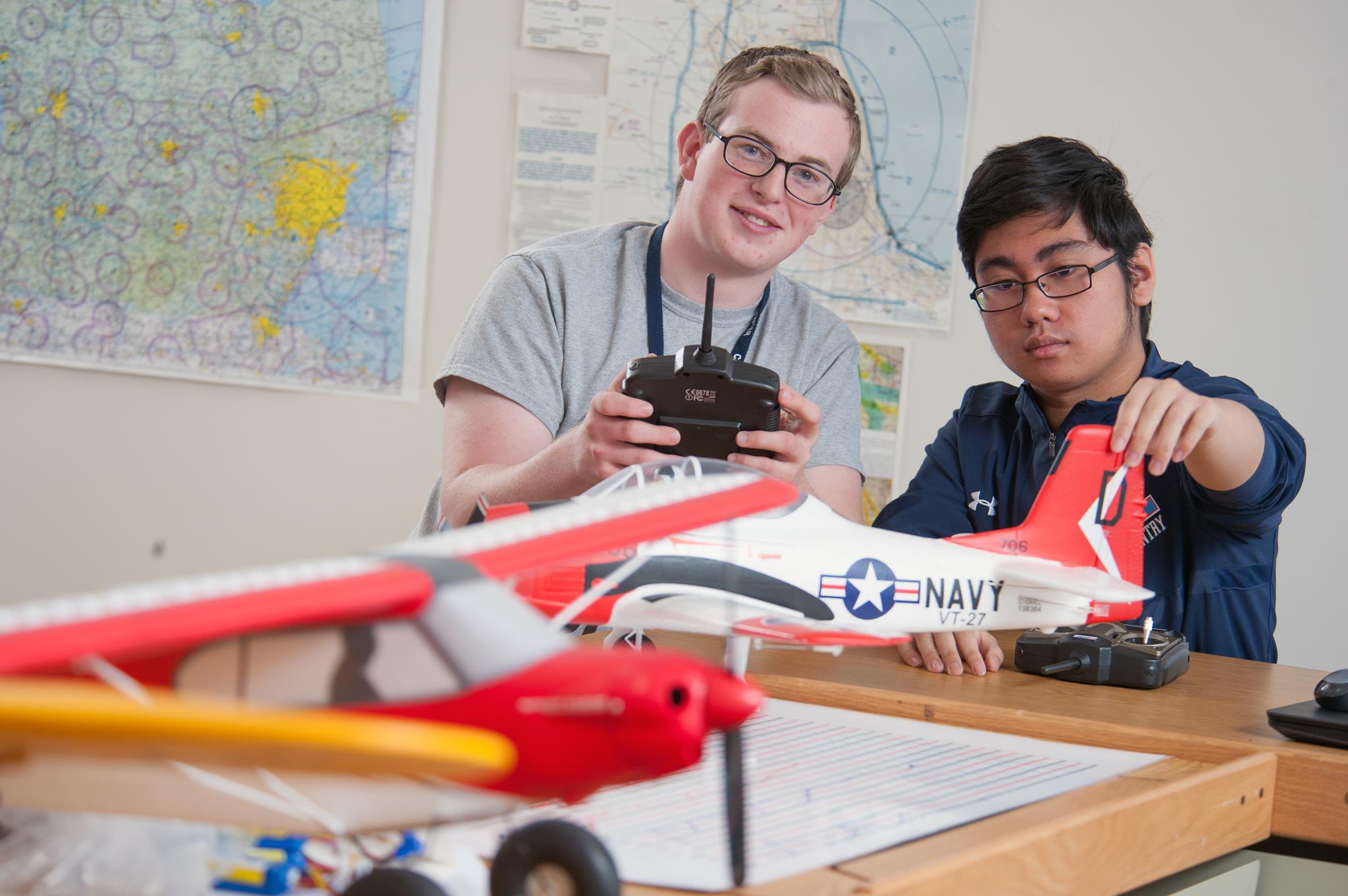 Two Aviation students prepare a model airplane for flight.