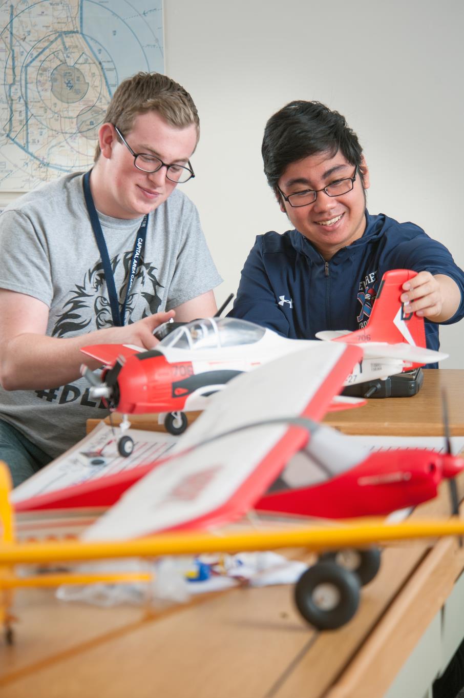 Two Aviation students work on a model airplane.