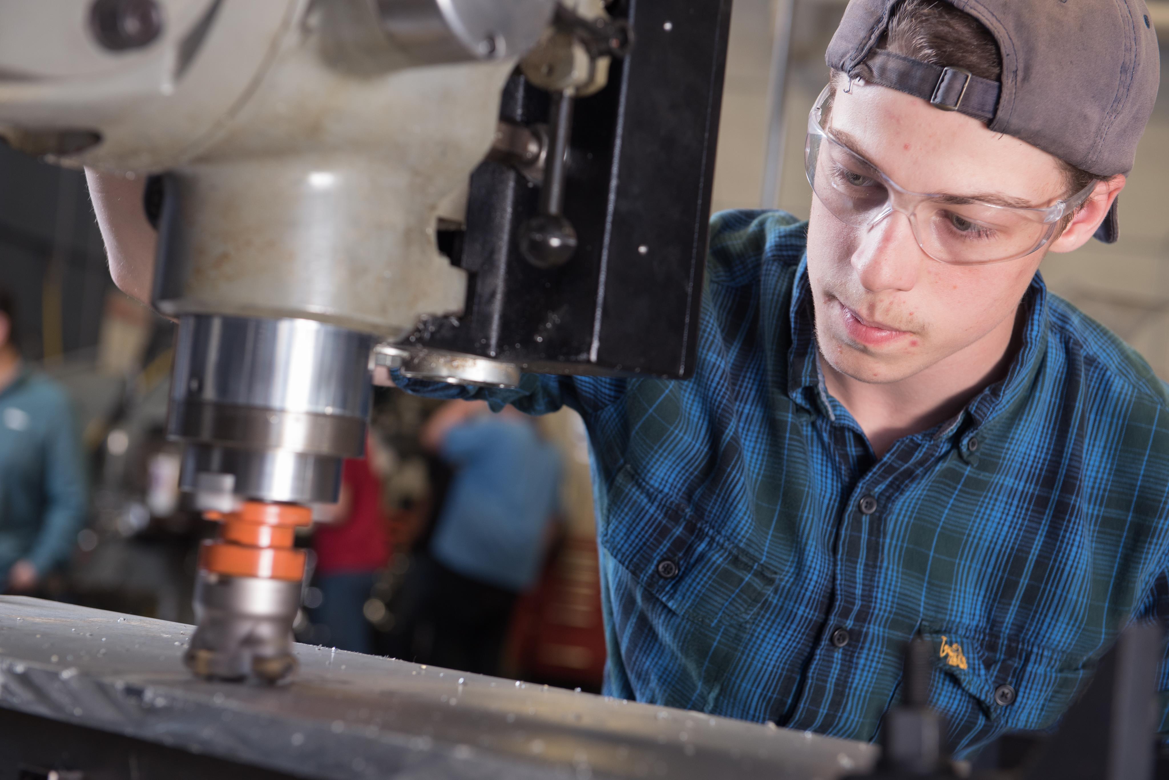 Male Precision Machining student working with equipment in class