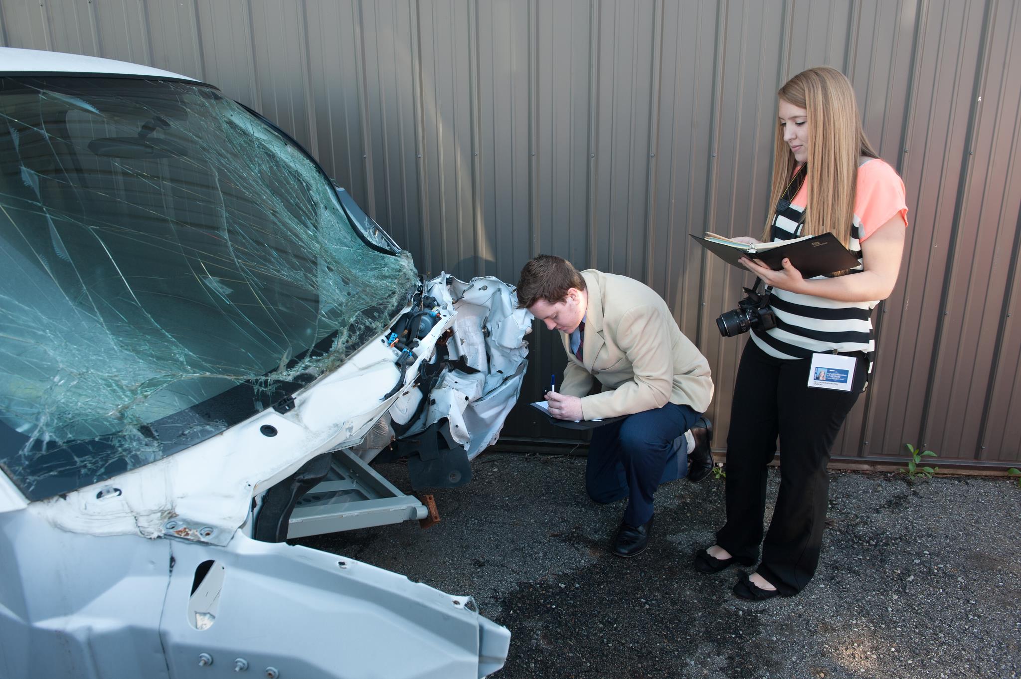 Two Business & Risk Management student review an auto claim.