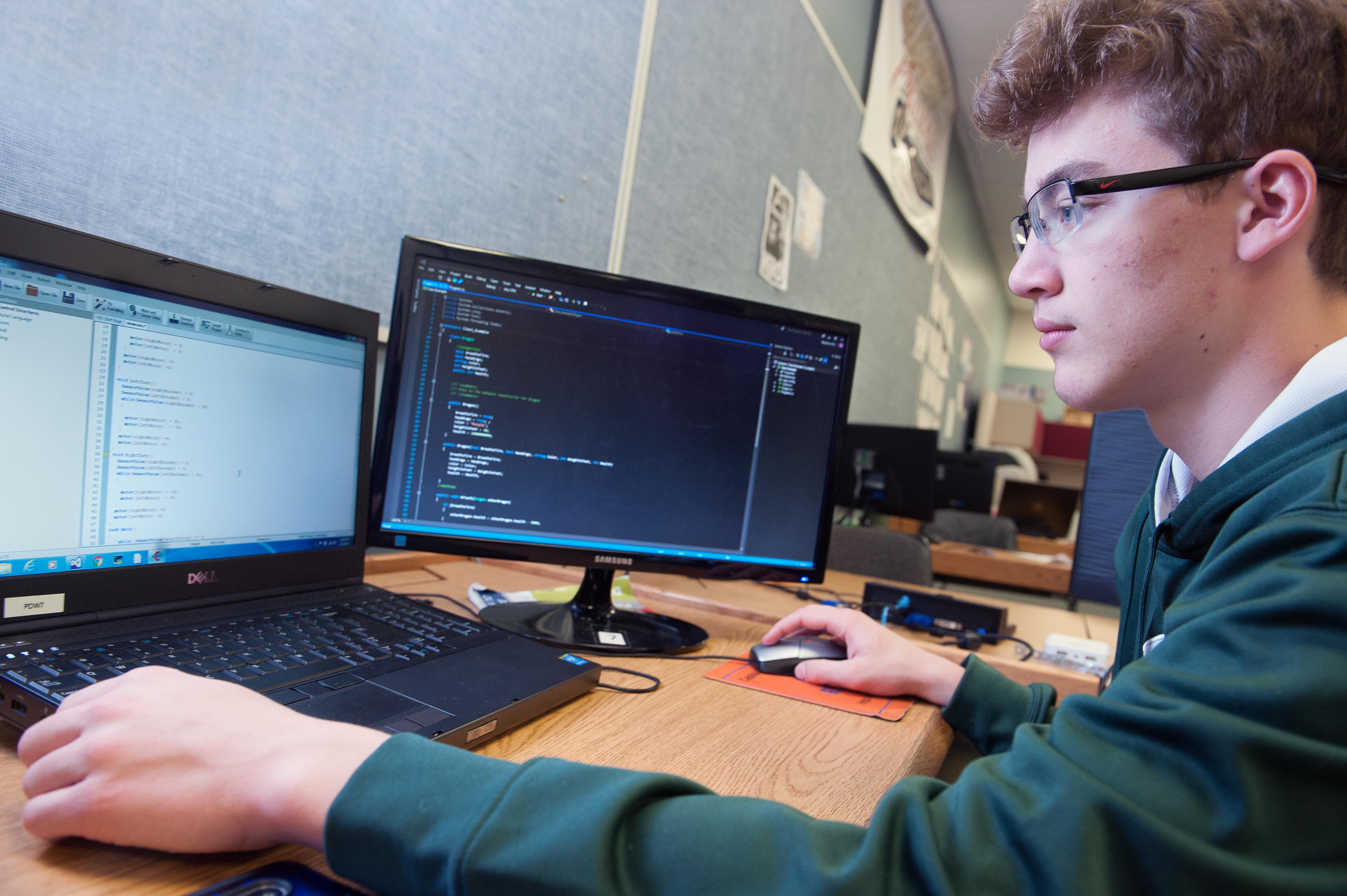 Male student works on his computer in the Programming class