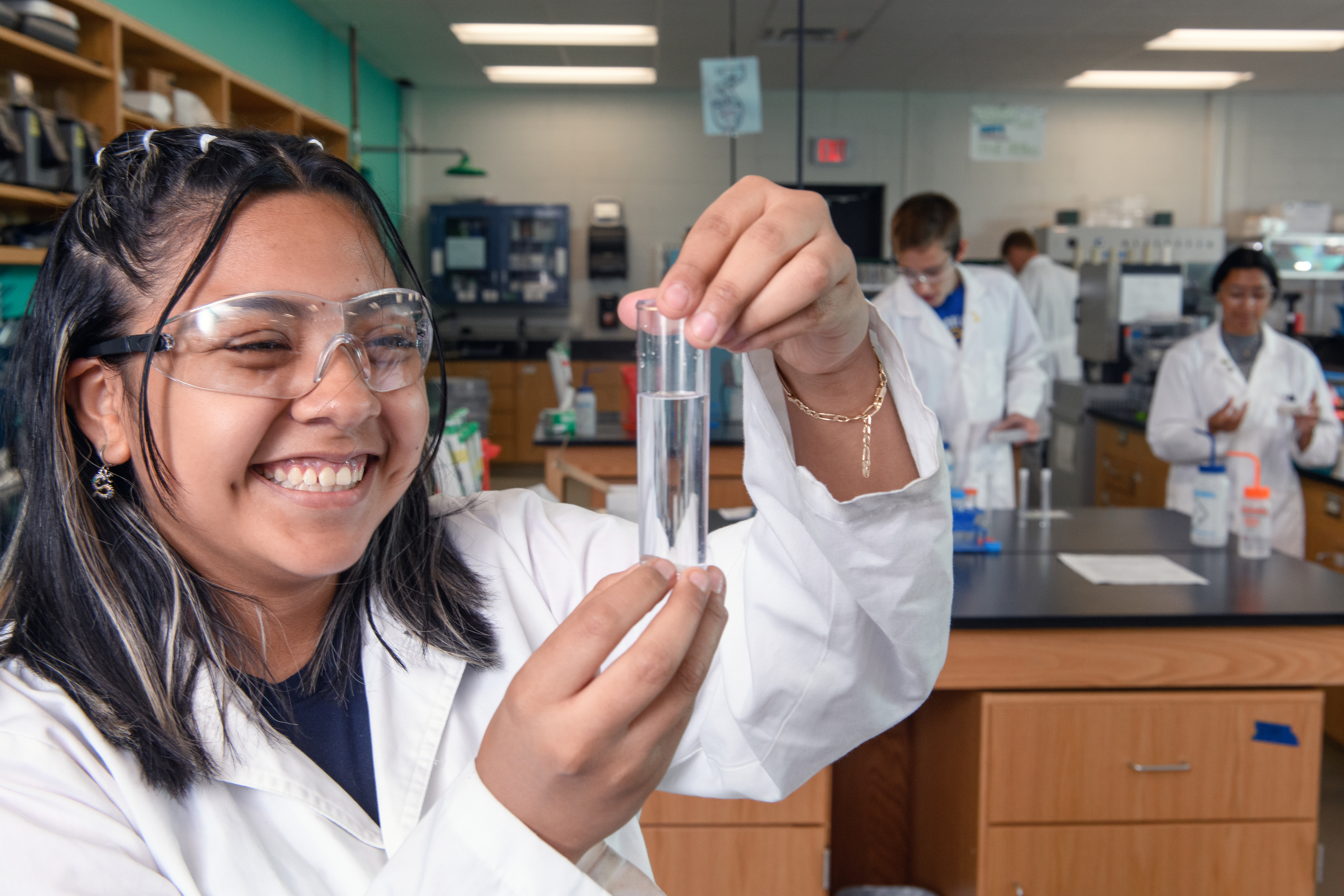 Female BioScience Careers student holds a test tube with liquid in it.