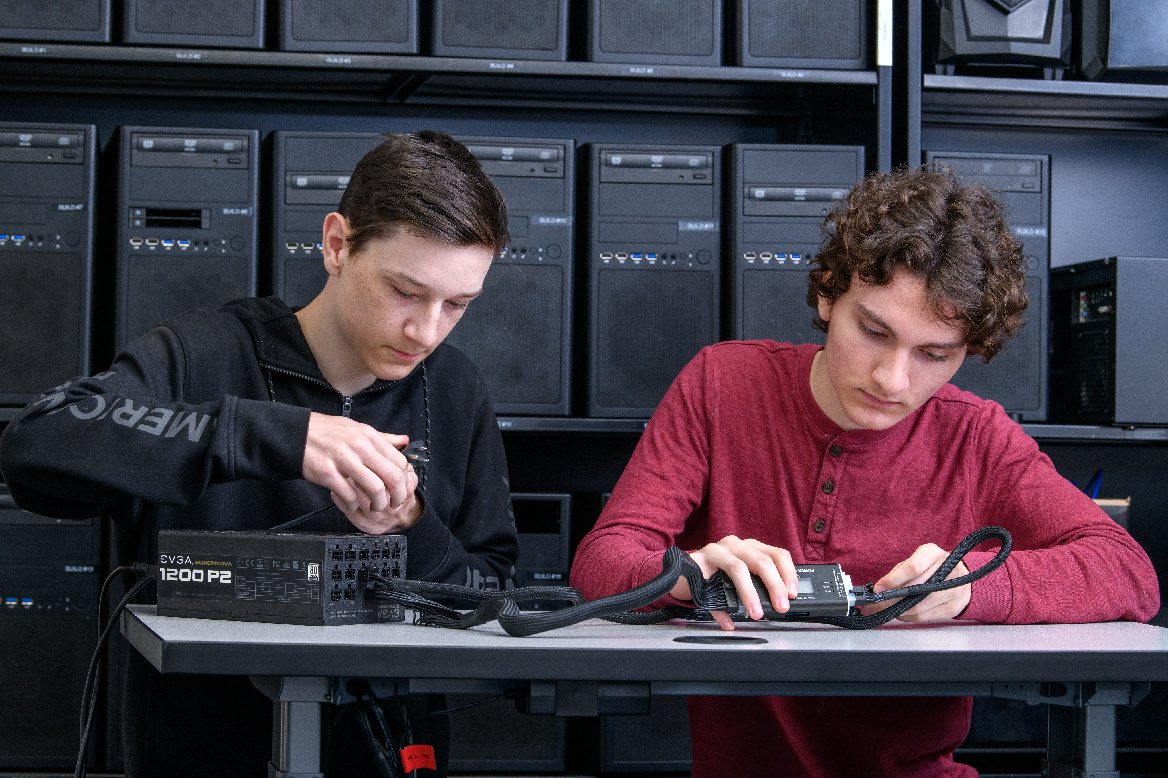 Two male Cybersecurity students work on equipment in their lab.