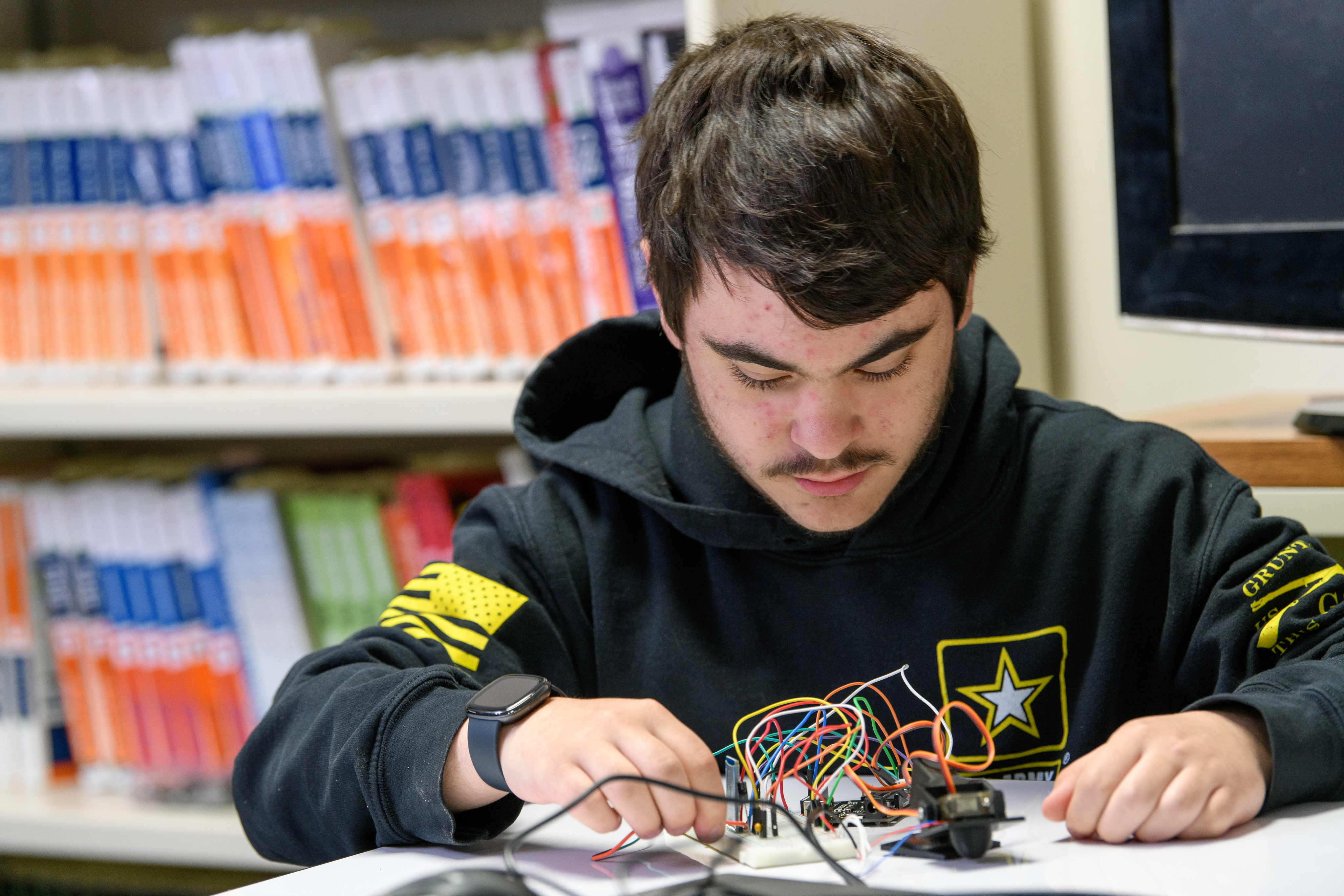 Programming student works on wiring a device.