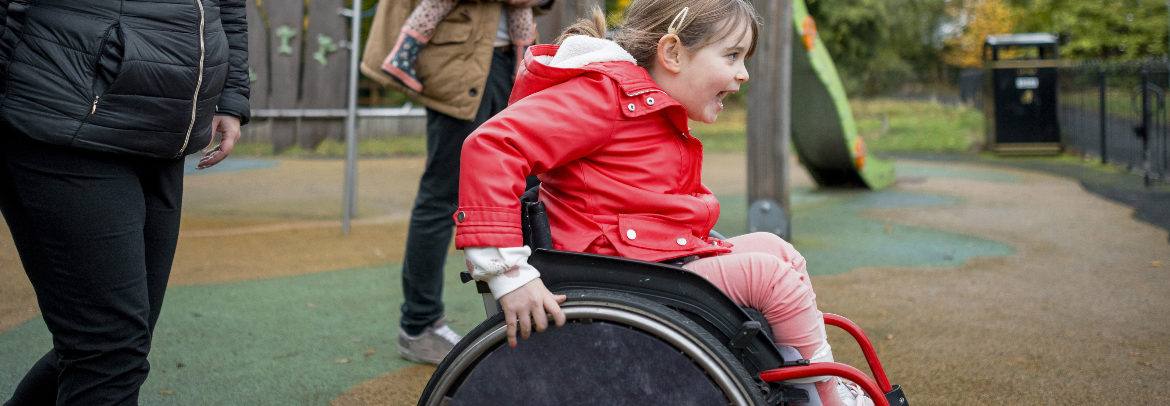 Young girl in her wheelchair racing outside